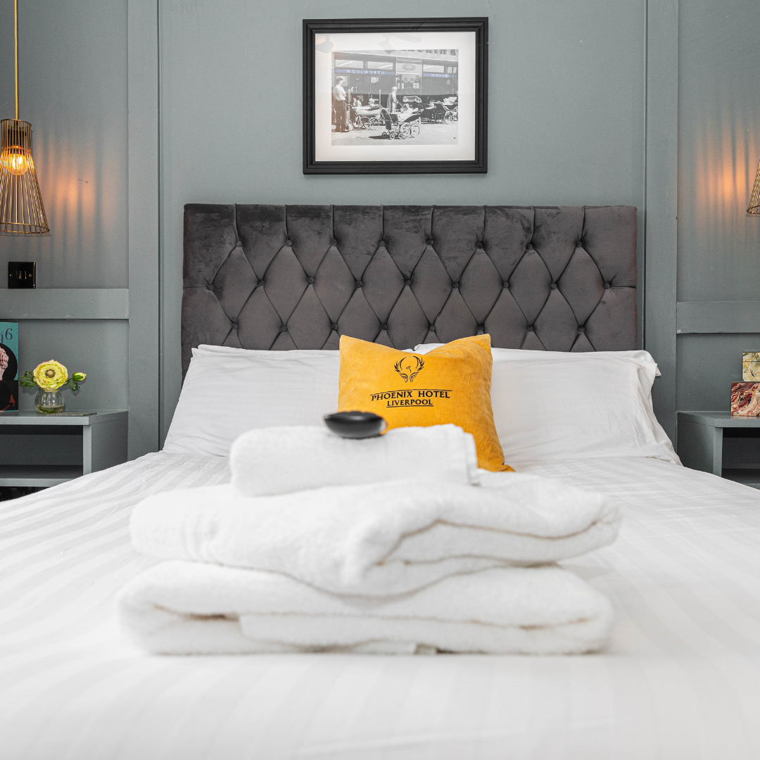 bedroom in phoenix hotel showing velvet headboard and pillow with towels stacked